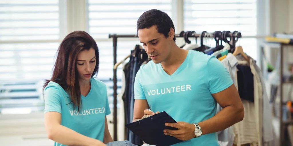 Volunteers wearing branded apparel during packing, representing same day hoodie printing Abu Dhabi services.
